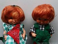 Front view of two Irish dolls with red hair in green and checkered outfits