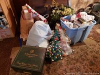 Overview of lot showing ornament box, ceramic trees, plastic bin, bags and other items