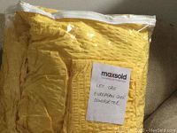 Comforter sealed in plastic bag with label for maxsold and lot details