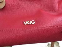 Close-up photo of the red leather handbag showing the metallic VÄGG logo