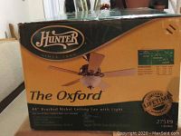 Box front showing Hunter brand and model The Oxford with 44" brushed nickel ceiling fan and light image and limited lifetime motor warranty badge.