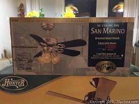 Original box showing Hampton Bay San Marino 36 inch ceiling fan with brushed steel finish and 5 reversible blades in black or rosewood.