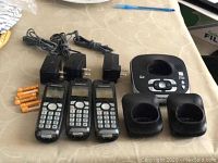 First set of Panasonic cordless phones: base unit with answering machine, three handsets, two charging bases, power adapters, and batteries.