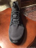 Front top view of one black Skechers shoe showing knit upper and lace detail.