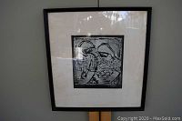 Front view of framed wood cut artwork depicting women in Bulgaria by Herta Galton, showing the whole frame and matting with some reflections on glass.