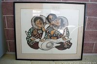 Framed painting showing three Native American figures with traditional attire and birds, hung behind glass.