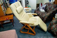 White leather recliner chair with wooden base in room setting