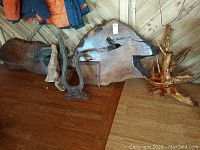 Seven large handcrafted live edge wood pieces, including slabs and twisted branch pieces, arranged on wooden floor and wall background.