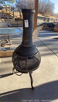 Photo showing entire chiminea outdoor fireplace standing on patio, highlighting shape and size.