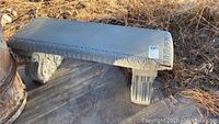 Concrete bench side view showing decorative carved edges and leaf motif supports