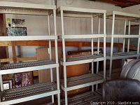 White plastic shelving units in garage setting showing multiple slatted shelves