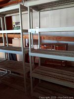 Two beige plastic shelving units positioned side by side in a garage setting, showing overall condition and size.
