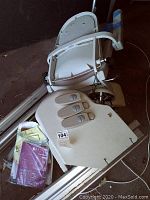 Photo of wired remote control panel with multiple buttons on beige base, part of stairlift setup.