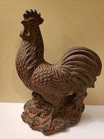 Side profile of the ceramic rooster showing detailed feather texture and natural earthy glaze.