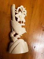 Photo of delicately carved bird perched on a branch with flower and leaves, showing detailed carving and off-white material, probably bone or horn.