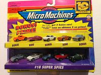 Front view of unopened set showing Micro Machines Super Spy Cars set in original packaging. Displays five bonus cars in blister pack and five base cars in bottom compartment.
