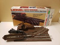 Photo showing the right-handed Lionel 027 gauge remote control track switch with the control box and original box behind