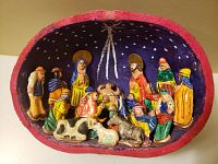 Front view of full Ecuadorian gourd nativity scene with all painted figures inside a hollowed gourd shell, showing starry night background and figures grouped around baby Jesus.
