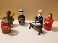 All six handcrafted wooden nativity figures arranged together on flat surface.
