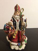 Figurine of St. Nicholas from Turkey dressed in traditional robes, holding gift basket and staff