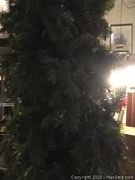 Close-up of middle section of the green artificial Christmas tree showing dense branches.