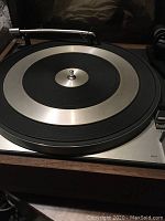 Close-up of the turntable platter and tonearm on a wood base, showing metal and black components with Duel 1219 marking.