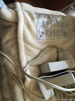 Cream-colored queen-size electric blanket with attached control unit and cords, showing texture and controls to verify working order.