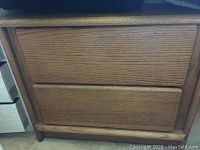 Close-up image showing the oak nightstand with two drawers and smooth front design.