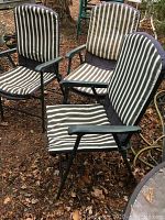 Three outdoor folding chairs with striped padded covers, showing front view and some sun fading.