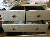 Linen chest with four drawers partially opened showing folded linens inside.