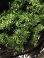 Close-up of green artificial Christmas garland showing plastic needles and texture.