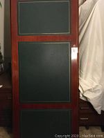 Full view of the wood desk top showing three inset green leather panels with gold trim.