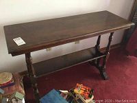 Full view of dark brown wooden hall table showing top, legs, lower shelf