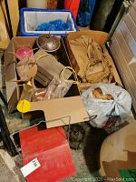 Box contains multiple bird feeders made of metal and plastic with hanging loops along with a bag and box of burlap fabric pieces