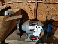 Front angle photo showing the entire Delta bench grinder with grinding wheels and tool rests.