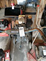 Side and top views of a heavily rusted MTD rototiller with a 5 horsepower engine and a 6.5 horsepower GX160 engine visible. The tiller has extensive rust on the engine, fuel tank, and tines, with a blue handlebar and a caution label.