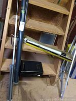 Microscope, telescope, and movie screen parts placed on wooden steps with tubes and tripod parts.