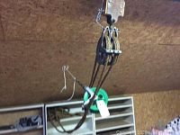Metal pulleys with multiple sheaves attached to the ceiling with thick rope threaded through.