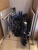 Photo showing the collection of wheelchairs and walkers arranged in storage area.