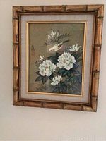 Full view of botanical floral and bird print in bamboo-style frame