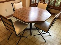 Octagonal laminate surface table with four chairs around it