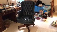 Full view of tufted leather desk chair in room