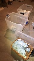Plastic tubs containing china items in basement