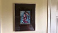 Print showing a full view of one framed oriental woman with parasol, in dark wood frame with gold inner trim
