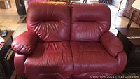 Front view of red leather powered loveseat in living room