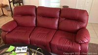 Front view of red leather three-seat reclining sofa in living room