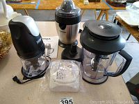 Overview of Ninja Master Prep Professional parts including motor base, blending cup, and blades alongside Cuisinart Citrus Juicer.