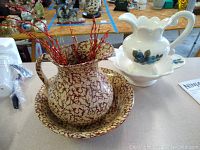 Both sets of wash basins and pitchers shown together on a tabletop