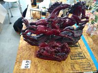 View of two reddish-brown resin Asian horse statues positioned on a wooden surface.