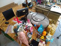 Photo showing entire lot with multiple electronic devices and various small decorative items on a table.